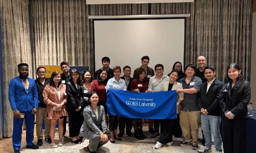 Trial class participants gathered around a GLOBIS University banner at the end of the session